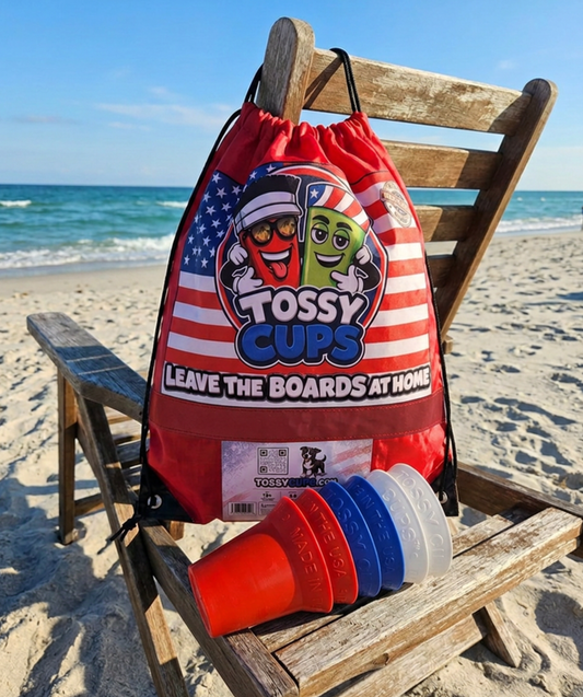 A red drawstring bag branded Tossy Cups at the beach, with  red, white, and blue,  Tossy Cups. The bag features a large patriotic graphic with Eddie and Chad announcing  TOSSY CUPS!

LEAVE THE BOARDS AT HOME!